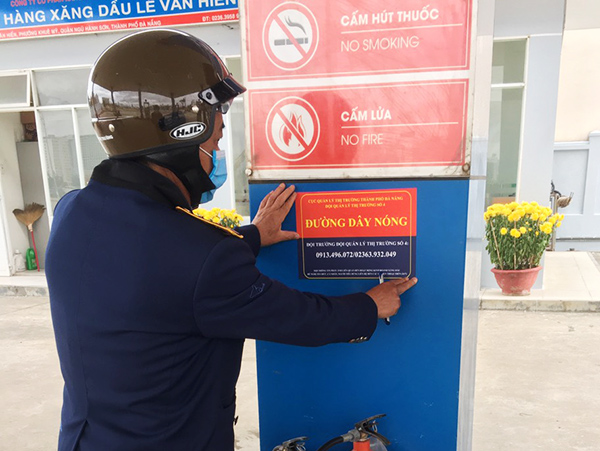 Lực lượng QLTT Đà Nẵng dán số đường dây nóng tại các cửa hàng kinh doanh xăng dầu để tiếp nhận phản ánh vi phạm